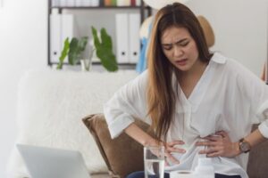 Woman experiencing IBS digestive symptoms during menstrual cycle - hormonal effects on gut health and perimenopause bowel changes